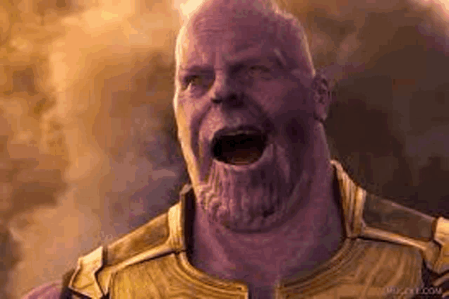 thanos from avengers infinity war is screaming with his mouth open in a close up of his face .