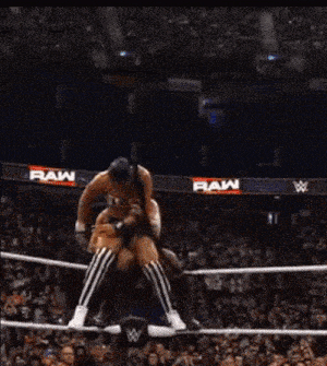 a woman is wrestling another woman in a ring with a w logo in the background .