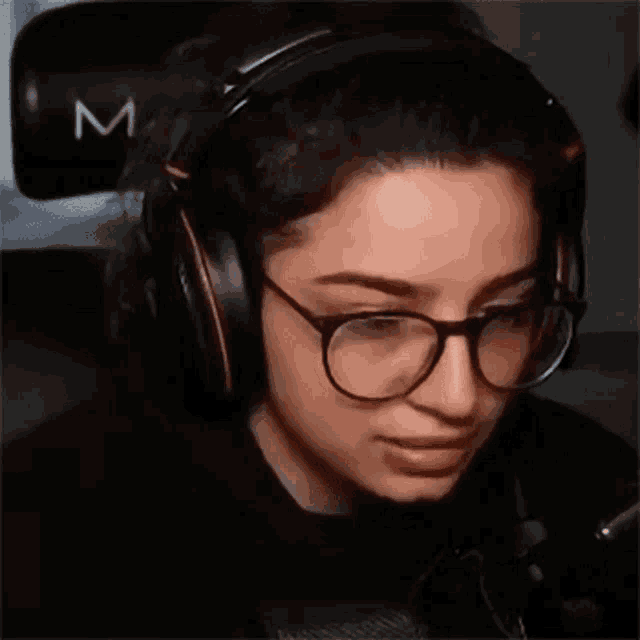 a woman wearing glasses and headphones is making a face .
