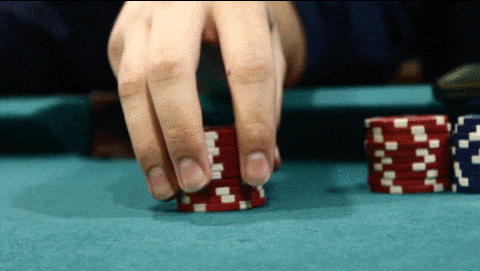 a person playing poker with a stack of red and white chips