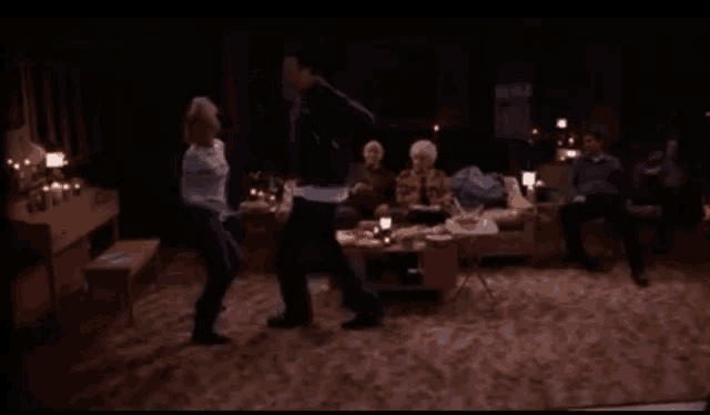 a group of people are dancing in a living room with a couch