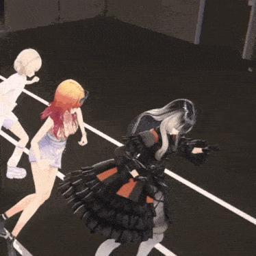 a girl in a black dress is kneeling down next to two other girls
