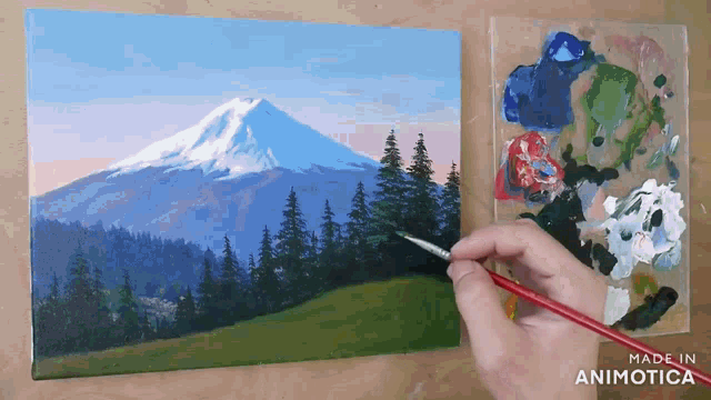 a painting of a mountain and trees is being painted on a canvas