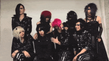 a group of people are posing for a picture and one of them has purple hair