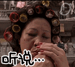 a woman with curlers on her hair is eating a hamburger .