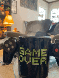 a game over coffee mug sitting on a table in a living room