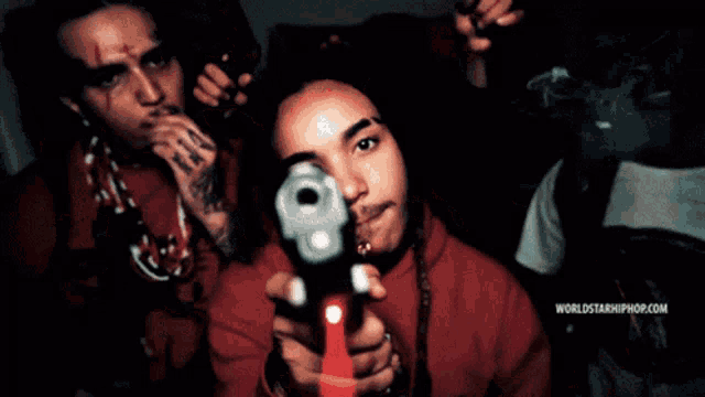 a man holding a gun with the words worldstarhiphop.com on the bottom right