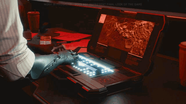 a person with a prosthetic arm is typing on a laptop that says work in progress on the screen
