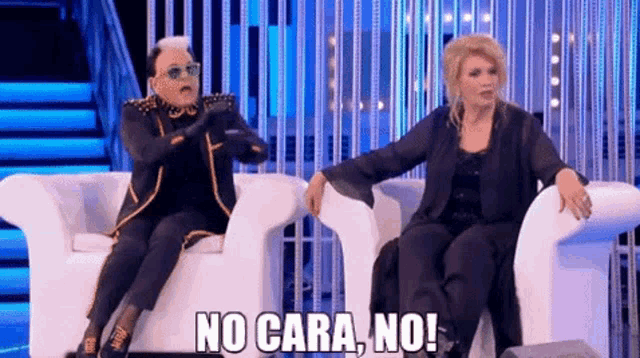 a man and a woman are sitting in chairs and one of them is saying no cara no !