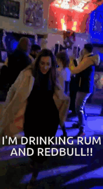 a woman is drinking rum and redbull while dancing at a party