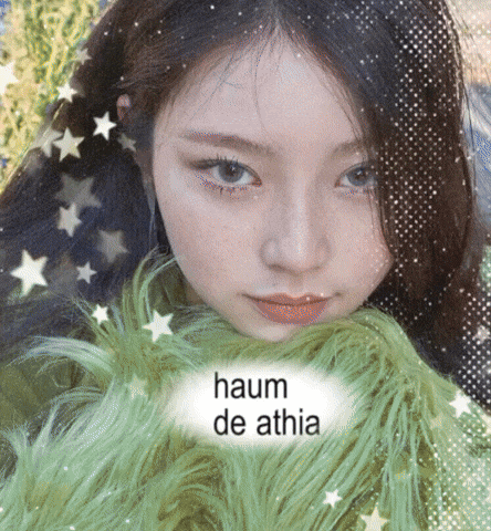 a woman wearing a green fur coat with the words " haum de athia " written on it