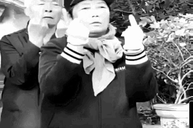 a man and a woman are giving the middle finger .