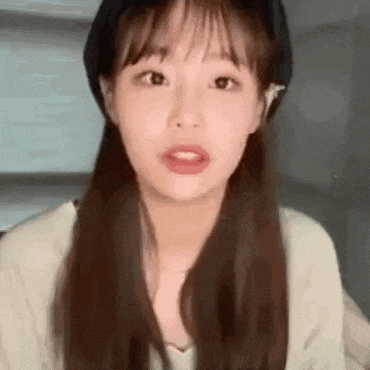 a close up of a girl wearing a hat and a sweater .