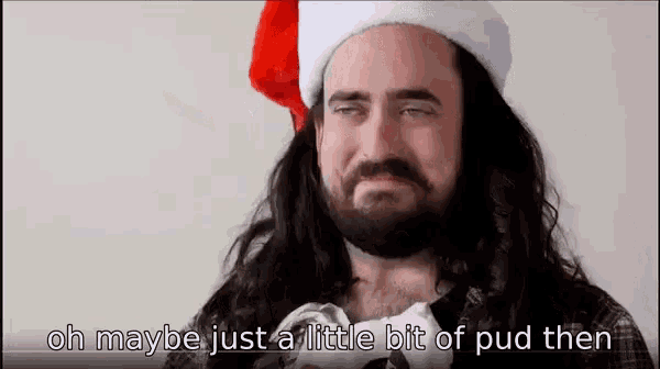 a man with long hair and a beard is wearing a santa hat and says oh maybe just a little bit of pud then .