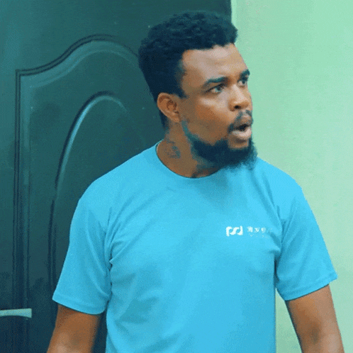 a man with a beard wearing a blue t-shirt that says ' rx9 ' on it