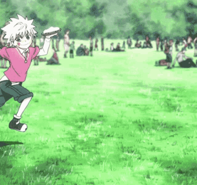 a boy in a pink shirt is holding a frisbee in a field