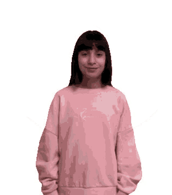 the girl is wearing a pink sweater and giving two thumbs up .