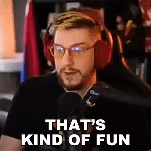 a man wearing headphones and glasses is talking into a microphone and saying that 's kind of fun .