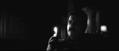 a black and white photo of a man talking on a cell phone .