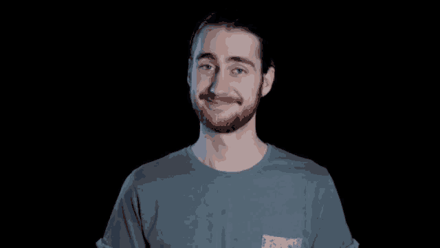 a man with a beard wearing a blue t-shirt with a pocket that says ' patagonia ' on it