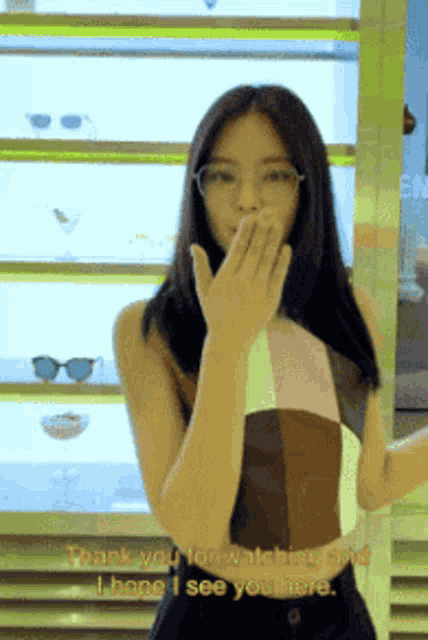 a woman wearing glasses is covering her mouth with her hand and saying thank you for watching and i hope i see you here
