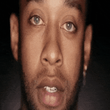 a man with a beard and blue eyes looks at the camera