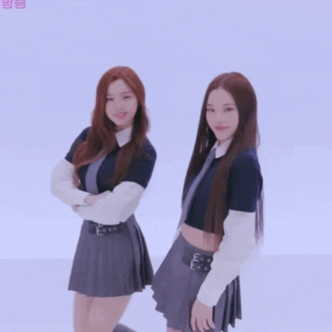 two girls in school uniforms are standing next to each other with their arms crossed