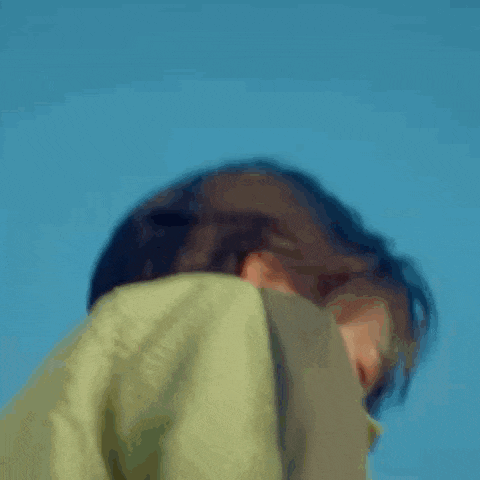 a close up of a person 's face with their eyes closed and a blue sky in the background .