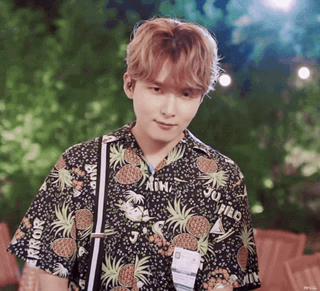 a young man wearing a black shirt with pineapples on it