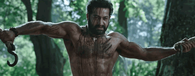a shirtless man with a beard is holding a hook