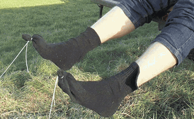 a person wearing a pair of black socks is laying in the grass