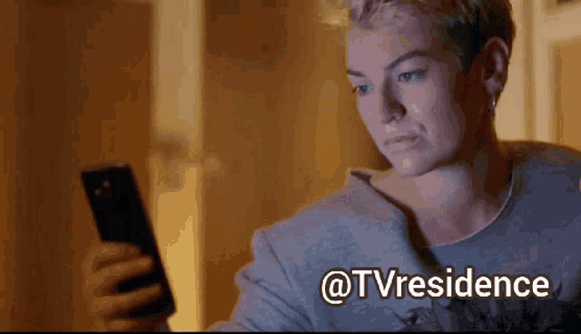 a woman looking at a cell phone with the hashtag @tvresidence