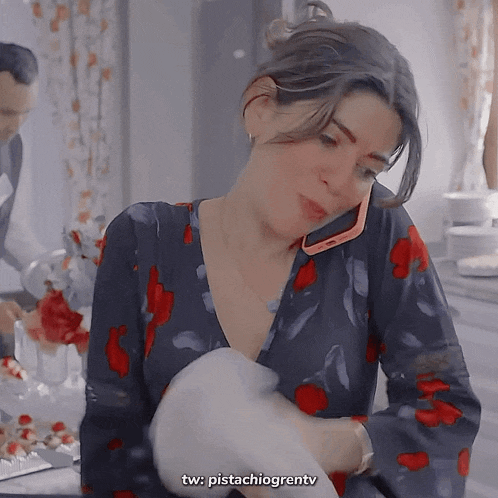 a woman in a floral dress is talking on her cell phone
