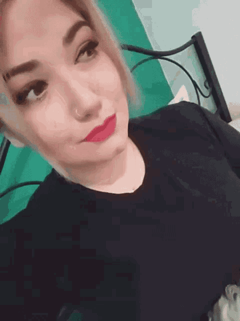 a woman wearing red lipstick and a nose ring