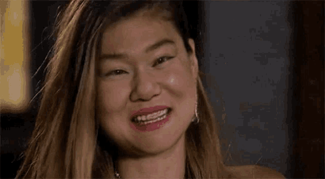 a woman with braces on her teeth is smiling for the camera .