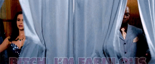 a man and a woman are behind a curtain with the words " bitch i 'm famous " written on it
