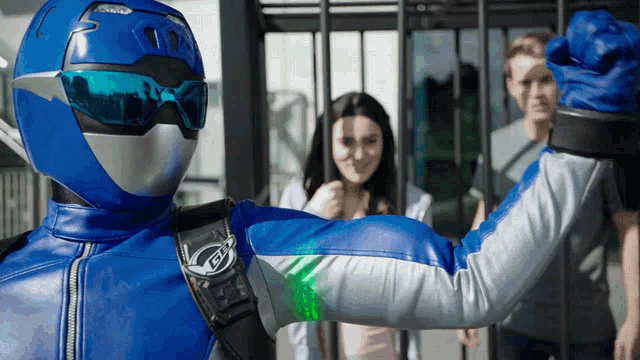 a man in a blue and silver superhero costume with a green light on his arm