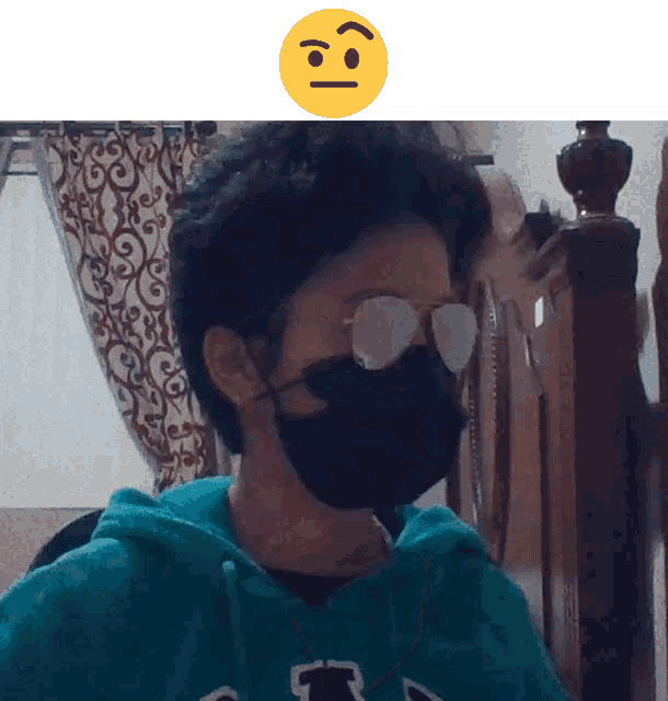 a man wearing a face mask and sunglasses has a smiley face above his head