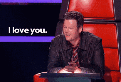 a man sitting in a chair with a sign that says i love you behind him