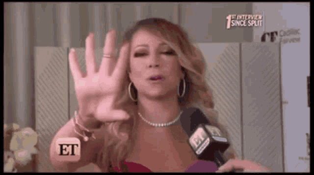 a woman in a pink dress is talking into a microphone with the word et on it