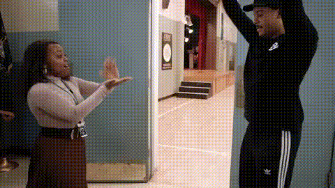 a man and a woman are giving each other a high five .