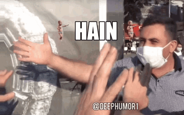 a man wearing a face mask is being interviewed by a group of people with the words hain written on the bottom