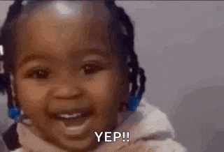 a baby girl with dreadlocks is smiling and saying yes .