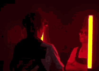 a woman is standing in a dark room with glow sticks in the background and talking about diamonds on me .