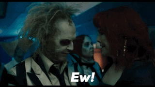 a man in a striped suit is talking to a woman in a blue dress with the words ew written on the bottom
