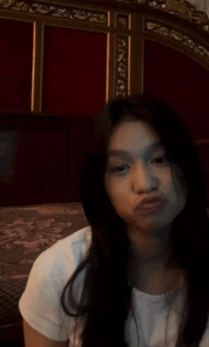 a young woman is making a funny face and giving a thumbs up