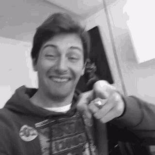 a black and white photo of a young man wearing a hoodie .