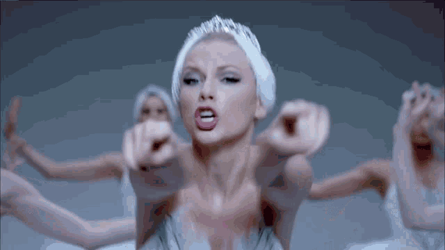 a woman in a swan costume is pointing her finger at the camera