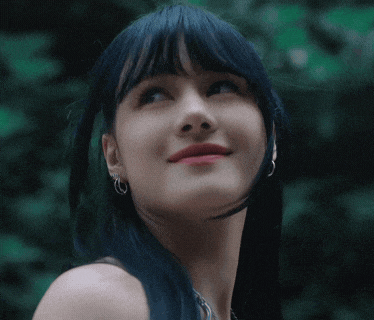a close up of a woman with blue hair and earrings