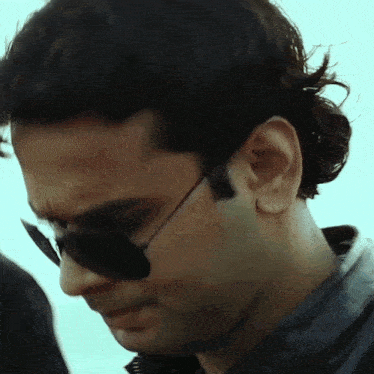 a close up of a man wearing sunglasses and a jacket